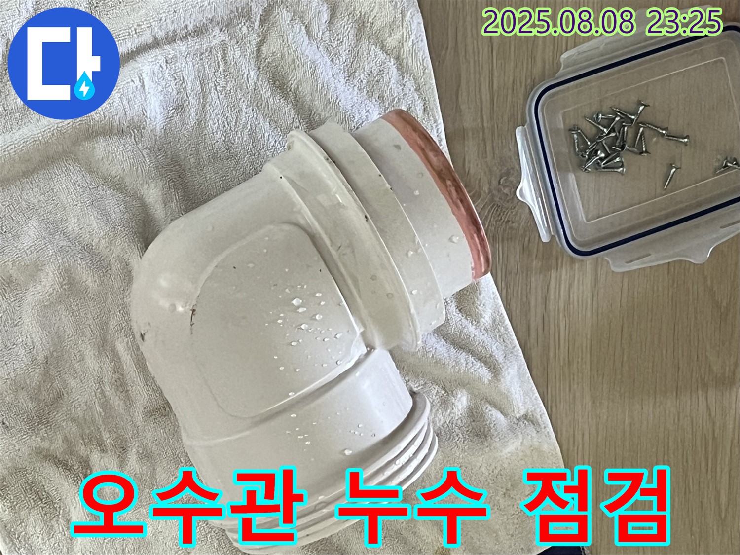 젖은 수건 위의 오수관 부속 - 오수관 누수 점검 중인 모습입니다.
