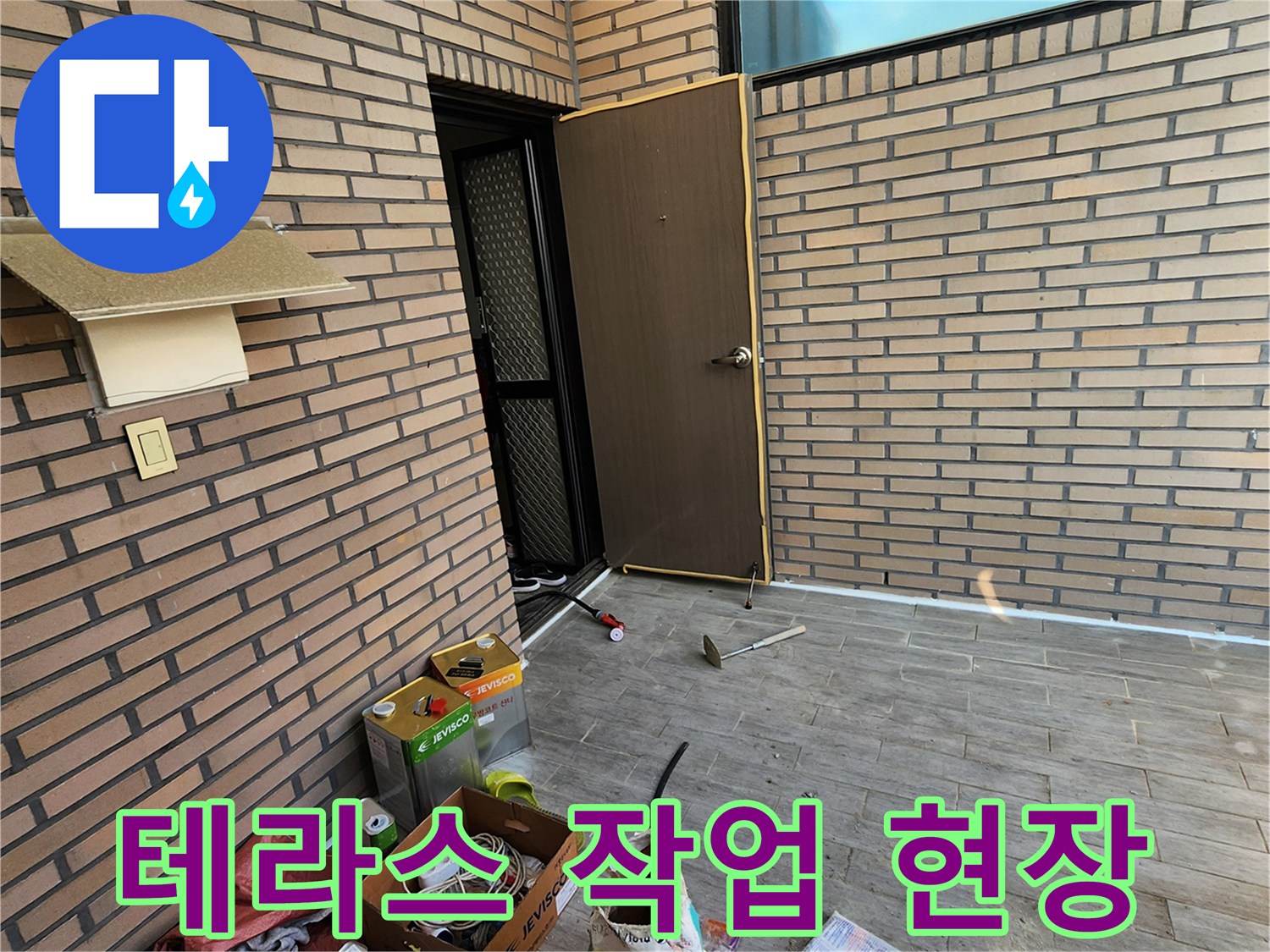 벽돌 외벽과 타일 바닥에 놓인 공사 자재 및 도구들