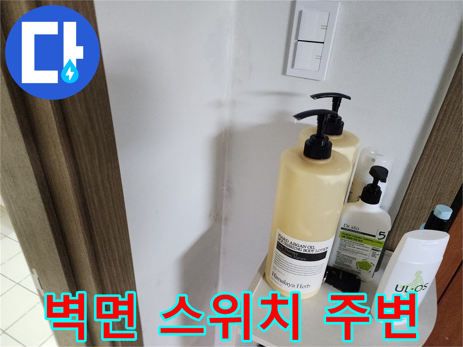 스위치 아래 놓여 있는 세정 용품과 벽면 상태