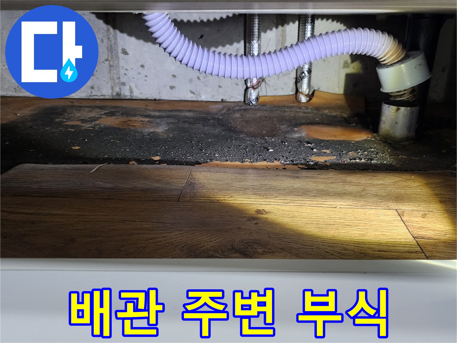 싱크대 배관 주변의 젖은 바닥과 부식된 마감재