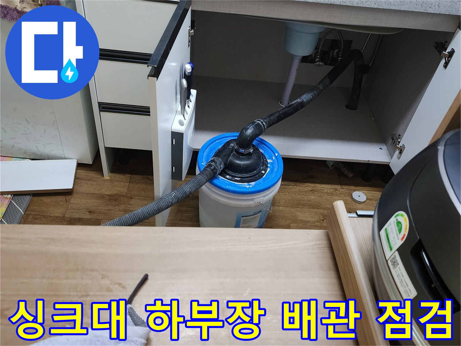 양주시 은현면 싱크대 하부장 내부의 배관과 잔수를 담은 양동이 모습