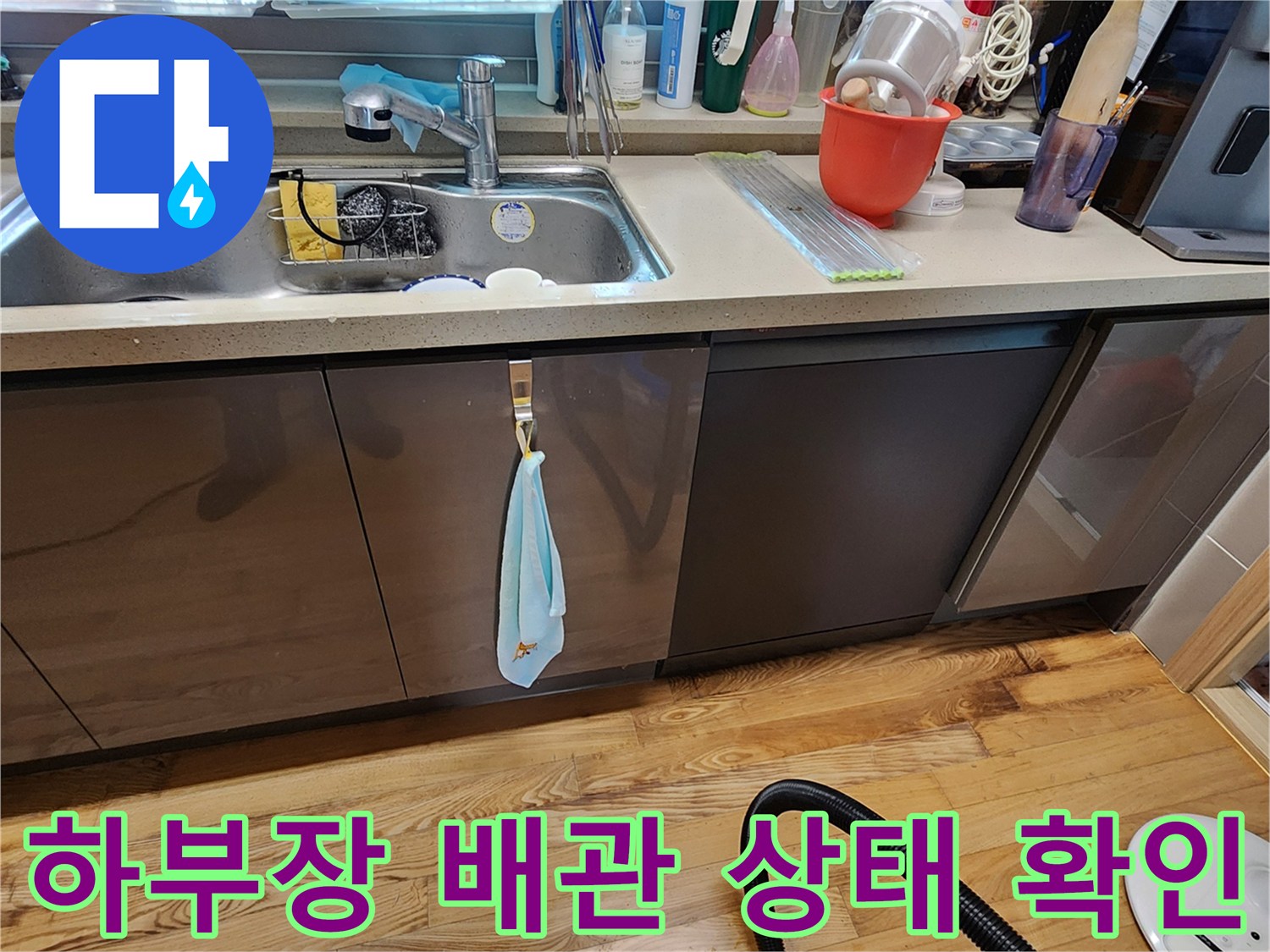 싱크대 아래쪽 수납장을 열어 내부를 살피고 있는 현장 사진