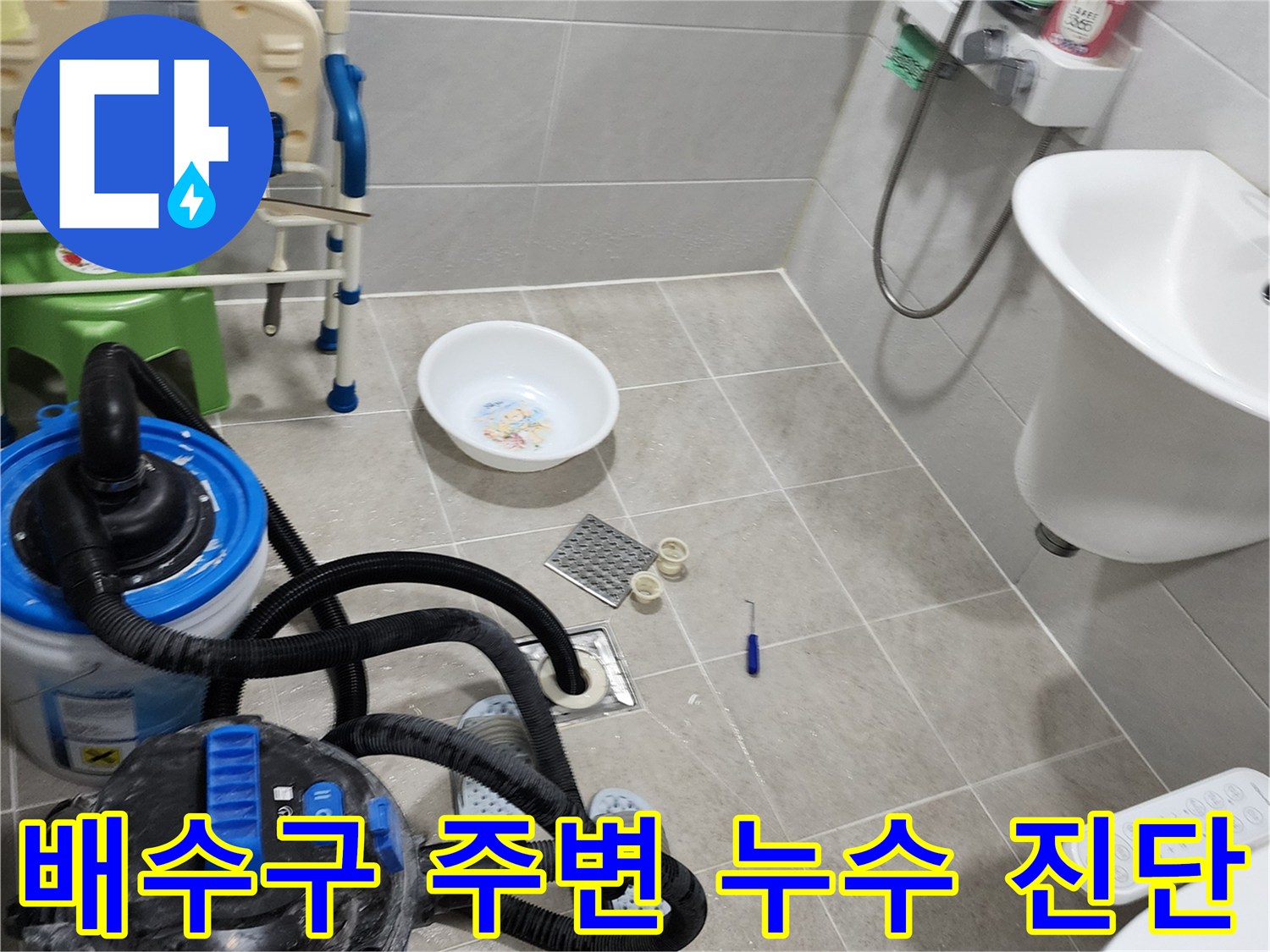 욕실 배수구 탈거 부위와 청소 장비가 놓인 현장 모습