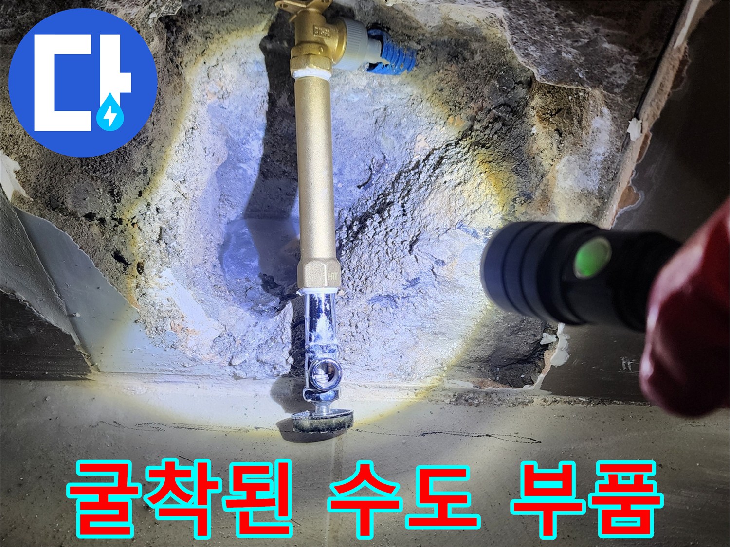 손전등으로 비춘 굴착된 벽면 속의 앵글밸브와 배관 연결부