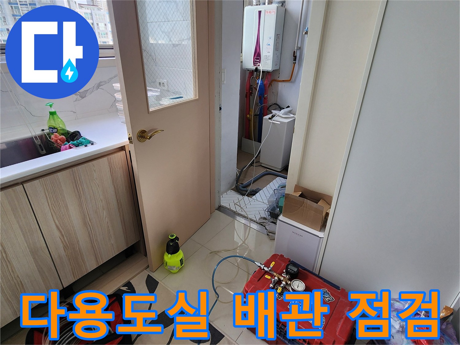 보일러 하단 배관과 압력 테스트 장비가 놓인 다용도실 모습