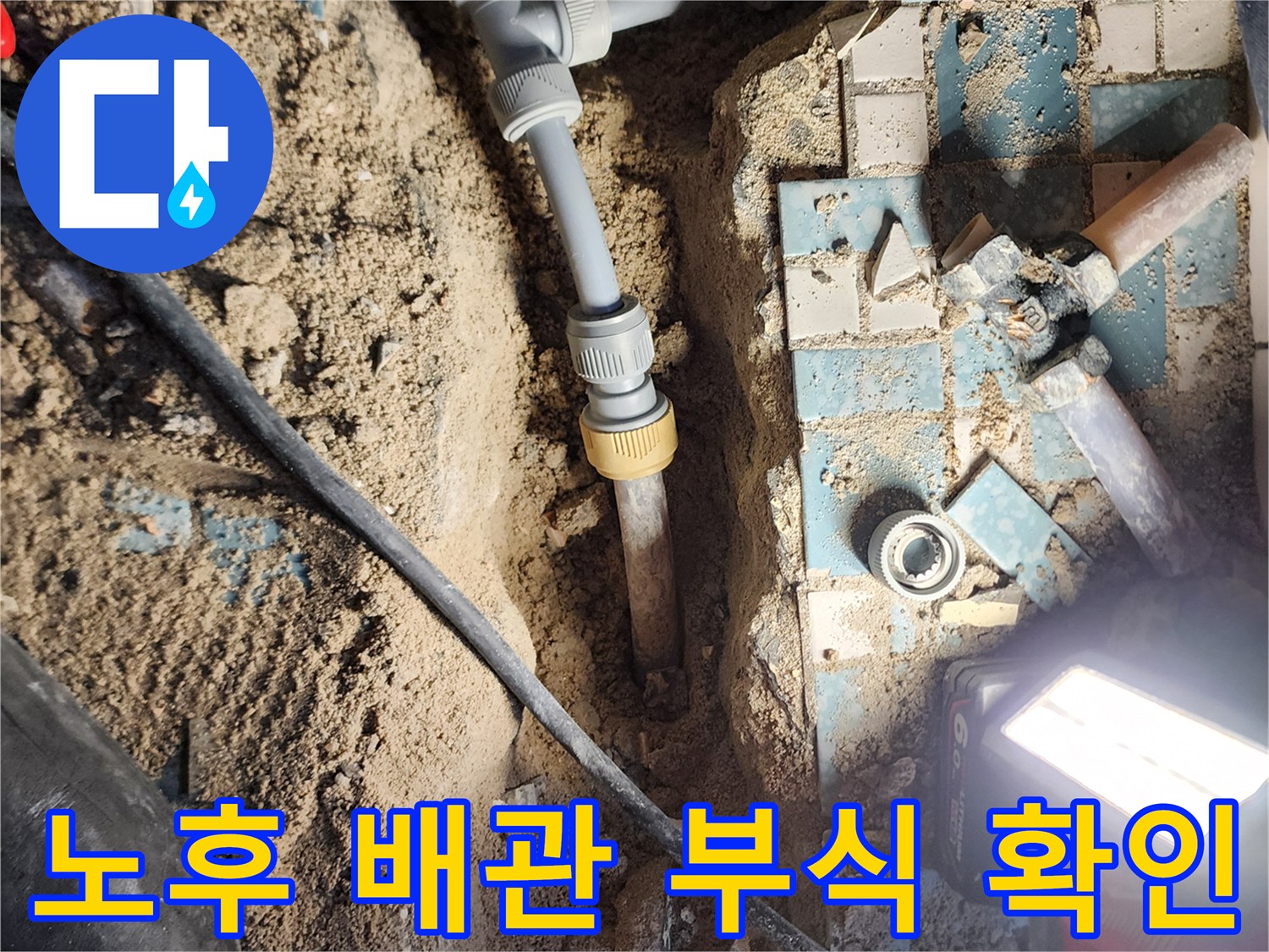 금속 배관의 연결 부위가 부식되어 물이 새고 있는 굴착 지점의 상세 모습입니다.