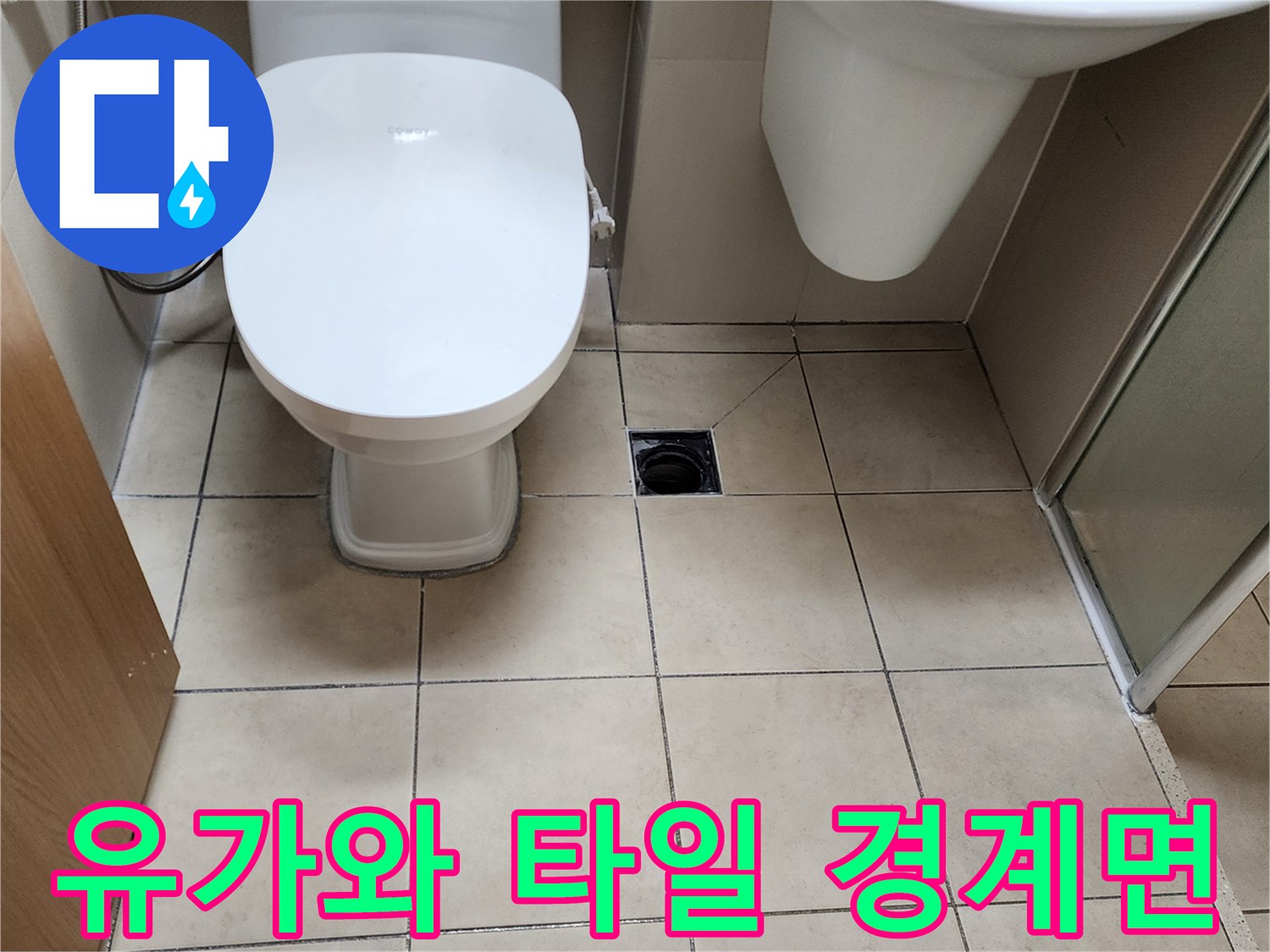 베이지색 욕실 타일과 검은색 배수구가 위치한 바닥 사진입니다.