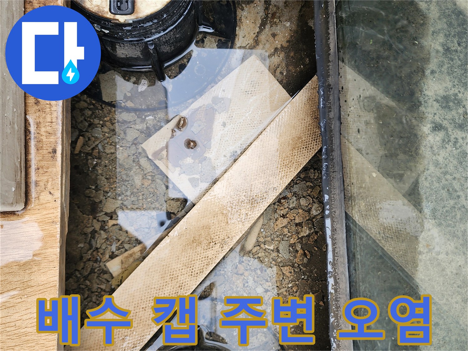 검은색 배수 캡 주위로 흙탕물과 이물질이 섞여 있는 모습입니다.
