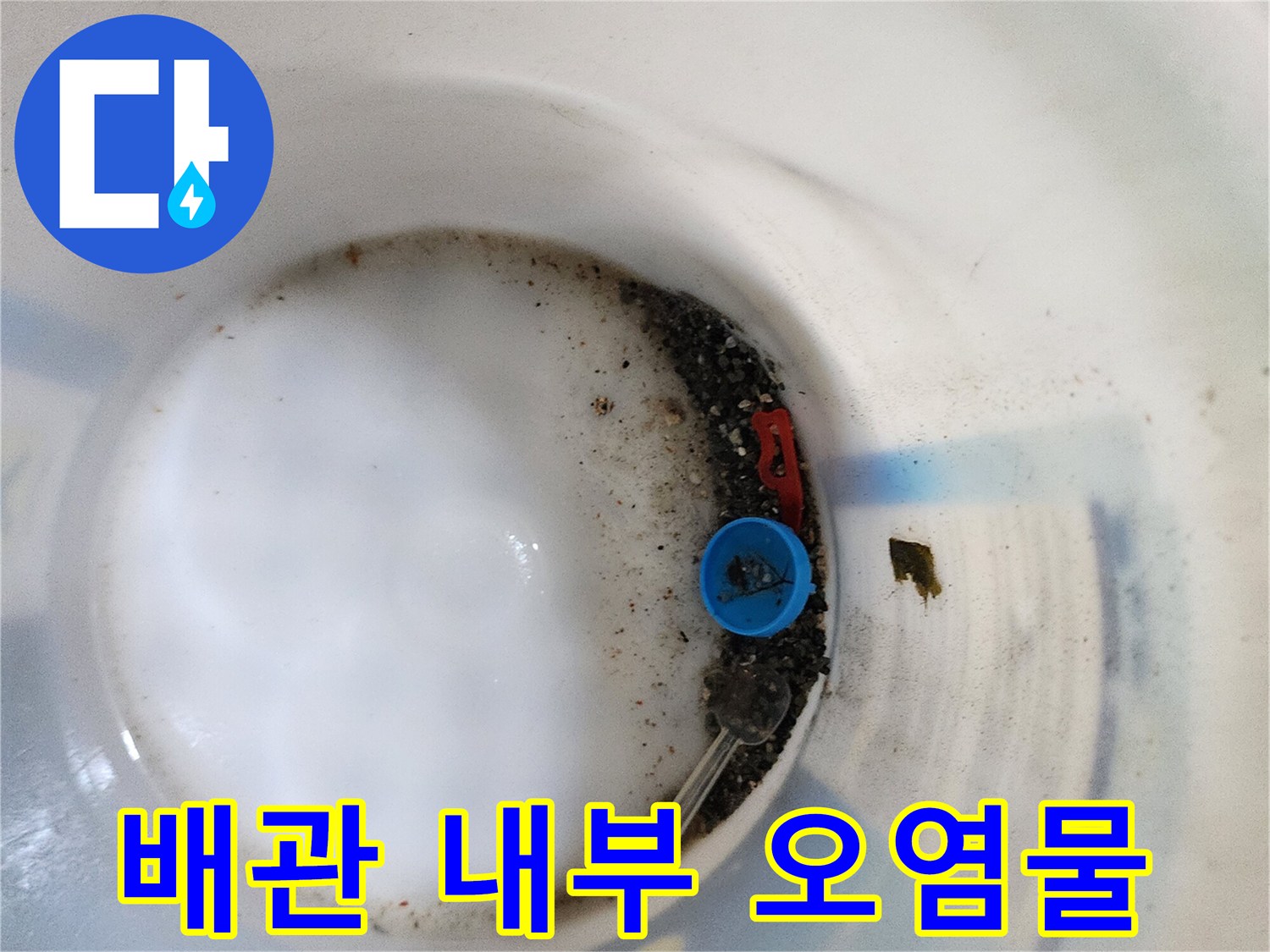 파란색 부품 주변에 쌓인 검은 찌꺼기와 물