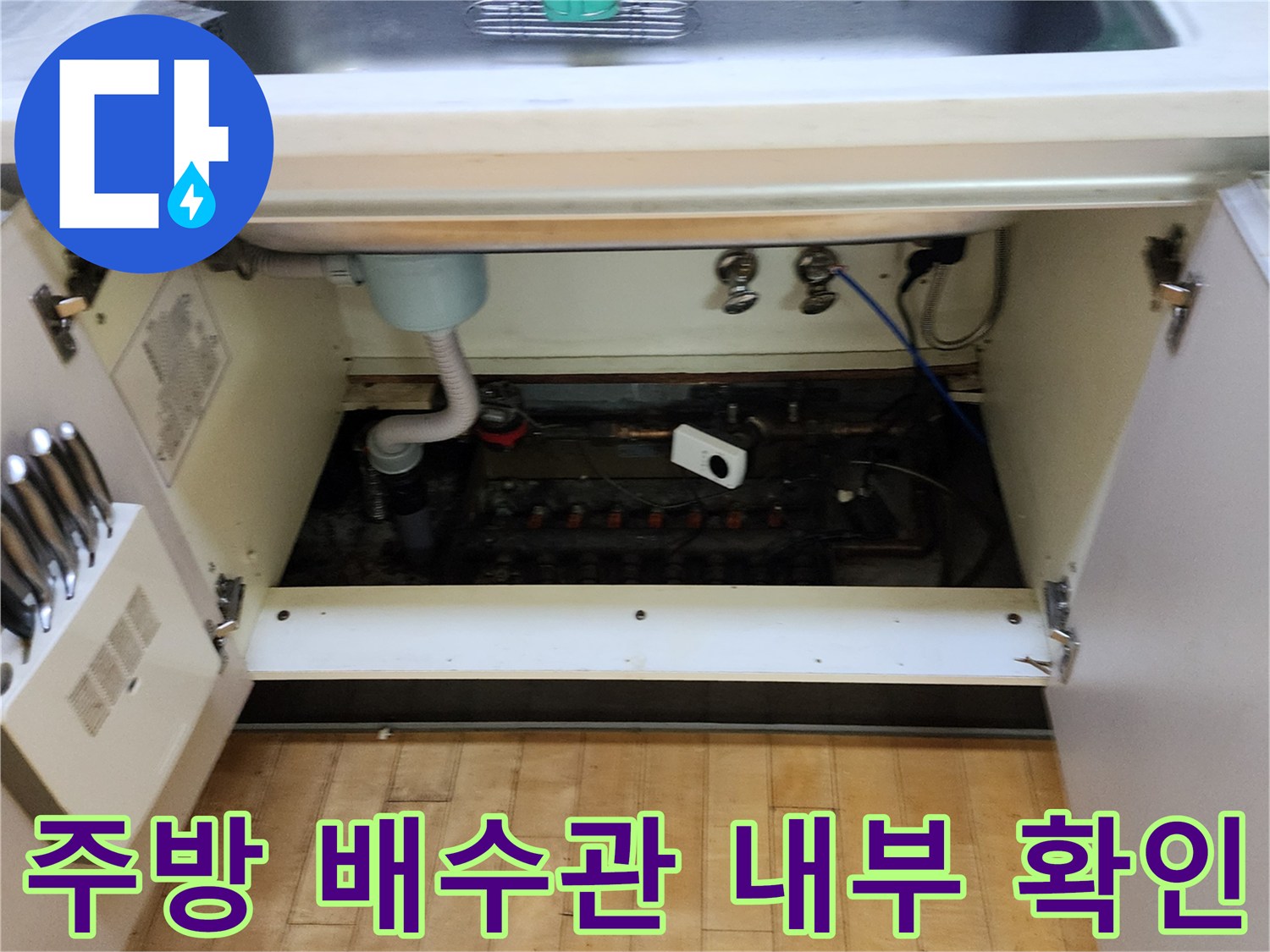 싱크대 밑바닥 배수 호스와 연결된 배관 함의 모습