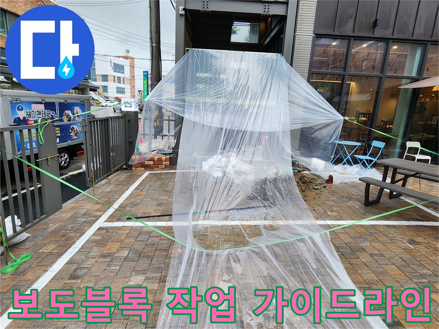 비닐막과 안전띠로 구분된 외부 보도블록 공사 구역