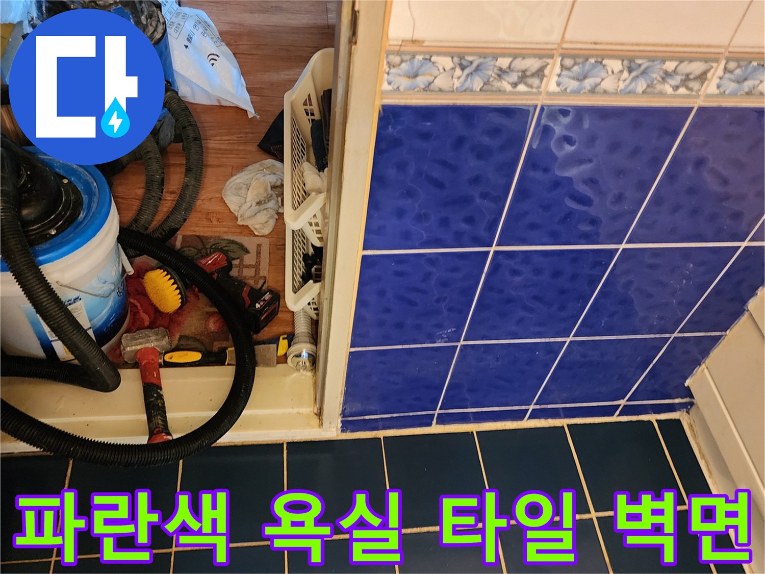 푸른빛의 욕실 타일 벽면과 작업 도구 세트