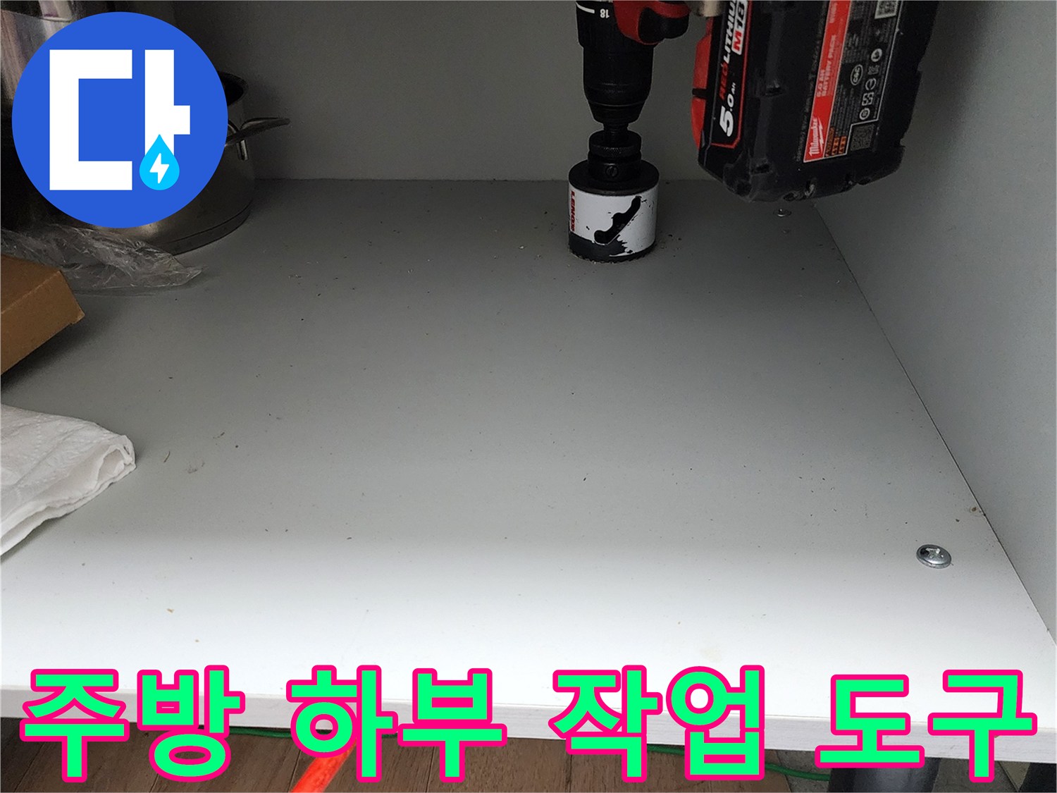 싱크대 밑 선반에 놓여 있는 전동 드릴과 소품들