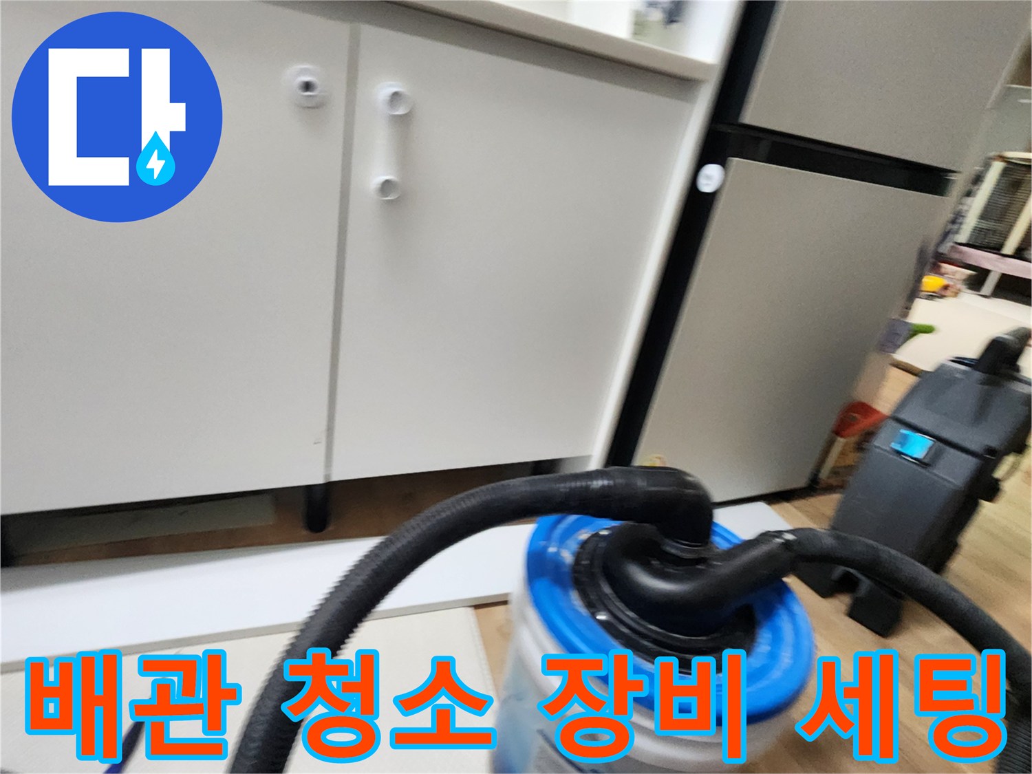 싱크대 하단 배관 관리를 위해 설치된 흡입 호스와 수거통의 모습