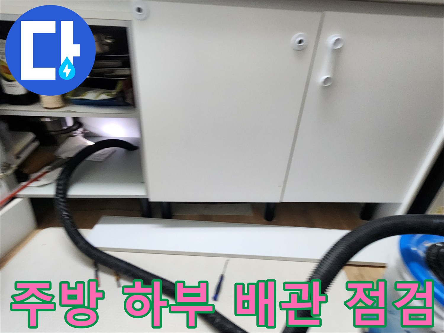 싱크대 하단 배관의 누수 여부를 확인하기 위해 열어둔 하부장 내부