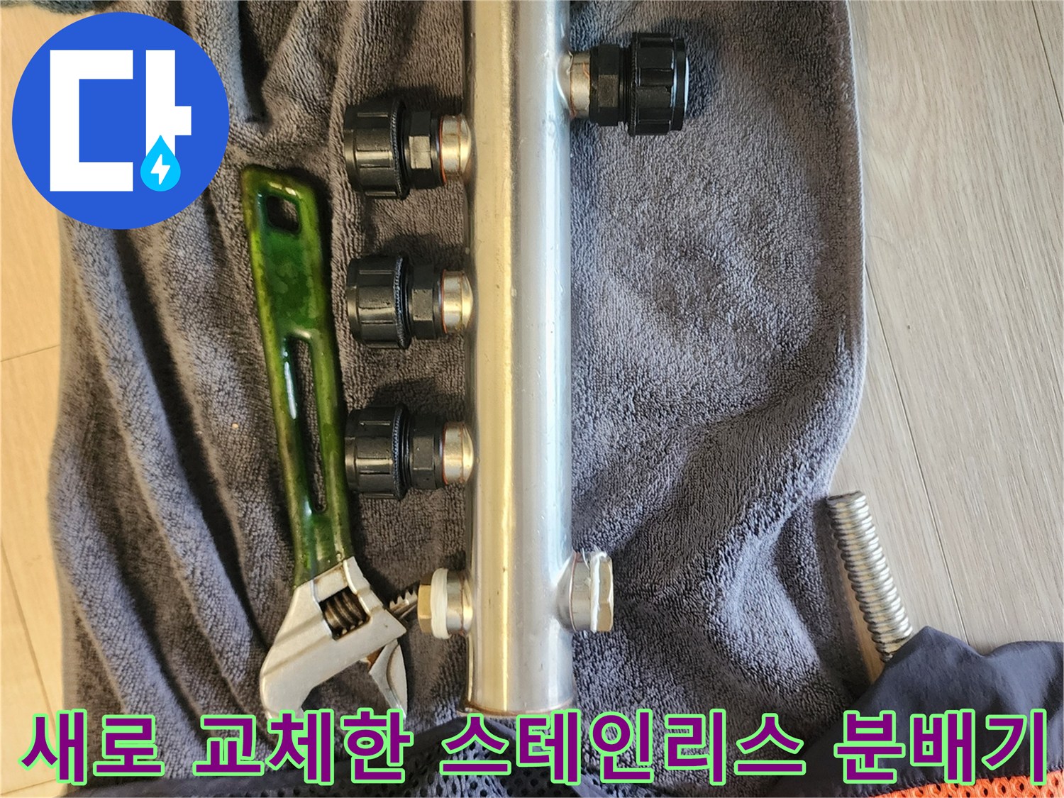 주방 싱크대 하단에 설치된-스테인리스 분배기와 몽키스패너