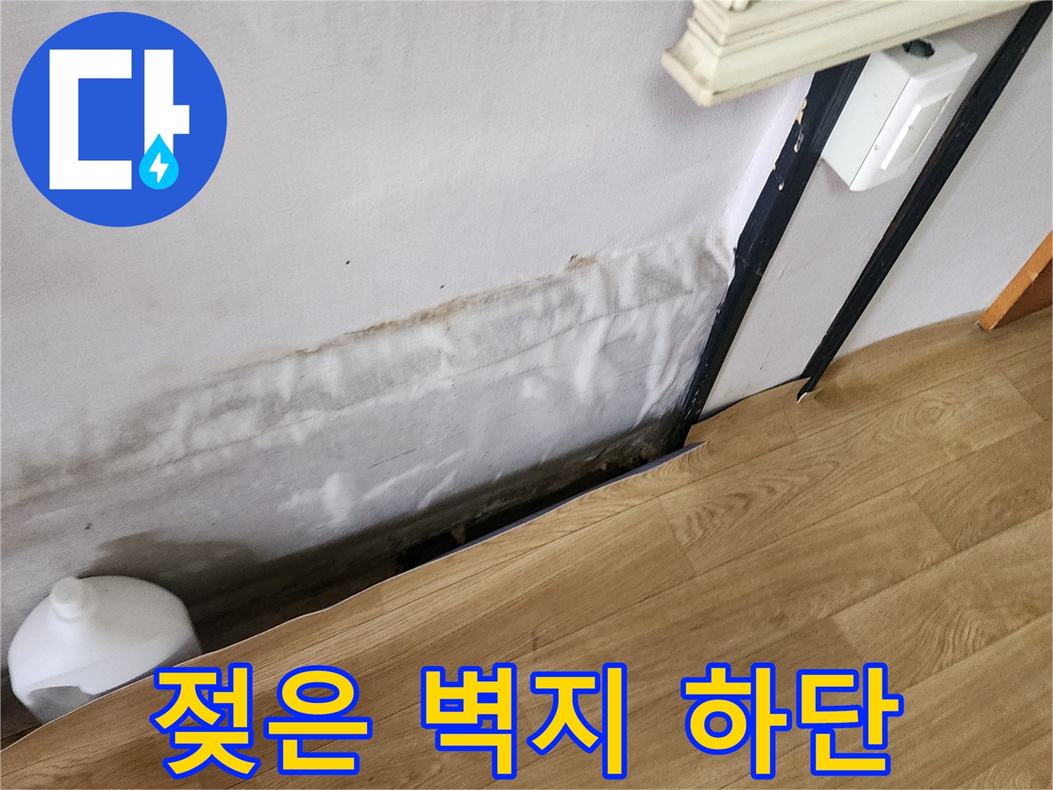 습기를 머금어 어둡게 변한 벽지 하단 부위