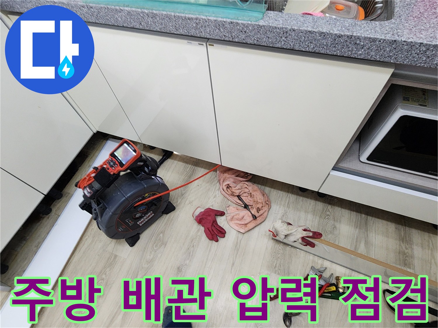 싱크대 밑 공간에 설치된 디지털 압력 게이지와 작업용 도구들