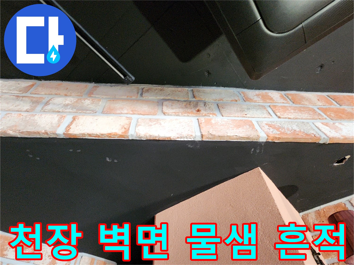 검은색 천장과 벽돌 벽 사이의 습기 침투 부위