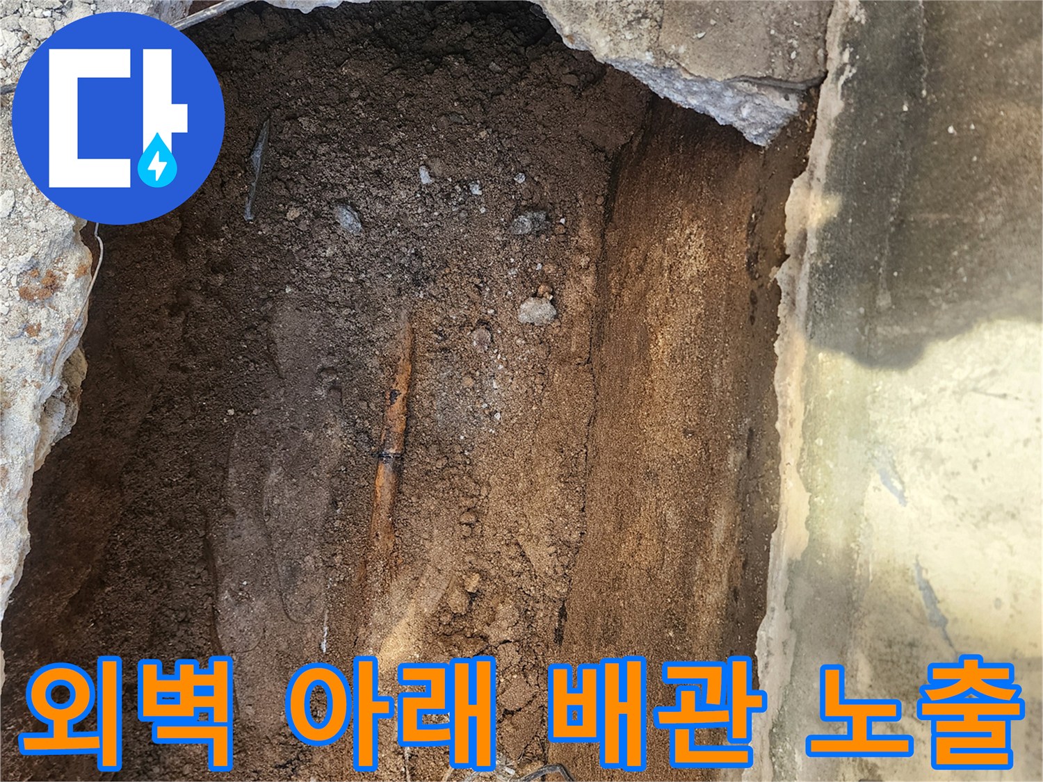 건물 외벽 하단-콘크리트 파쇄 후 드러난 매립 배관의 상태