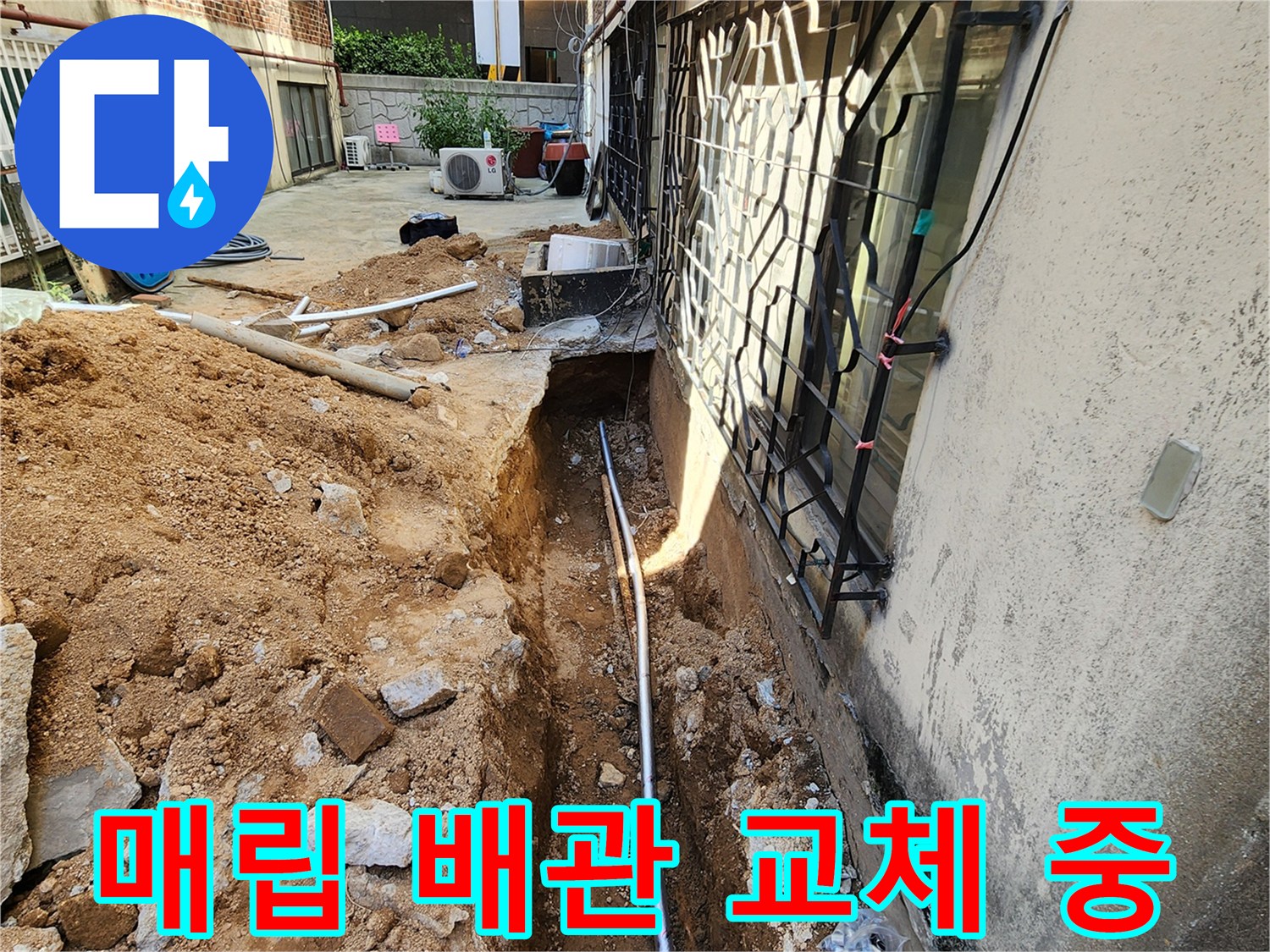 외벽 하단 굴착 부위에 새로 설치된 금속 재질의 배관 모습