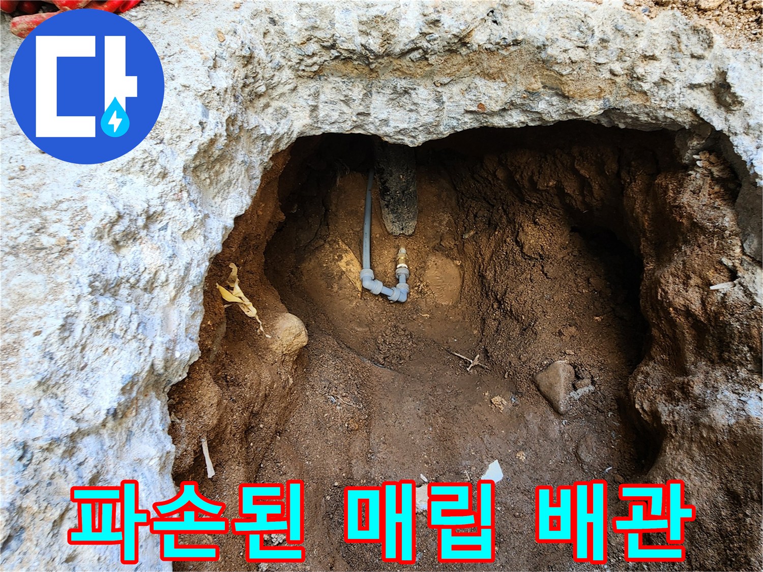흙과 콘크리트 사이로 노출된 파손된 배관의 모습