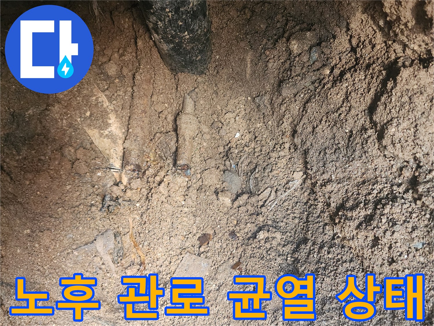 흙과 토사 사이로 드러난 노후된 배관의 균열 부위