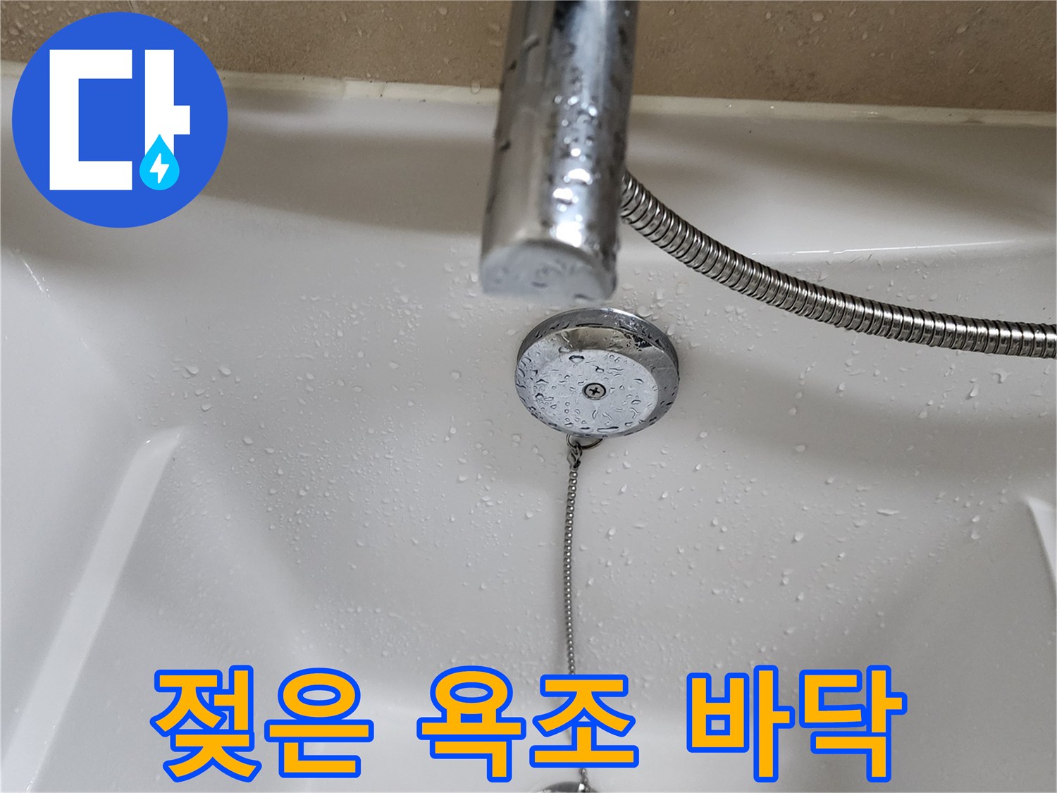물기가 맺힌 욕조 내부 배수구와 체인 모습입니다.