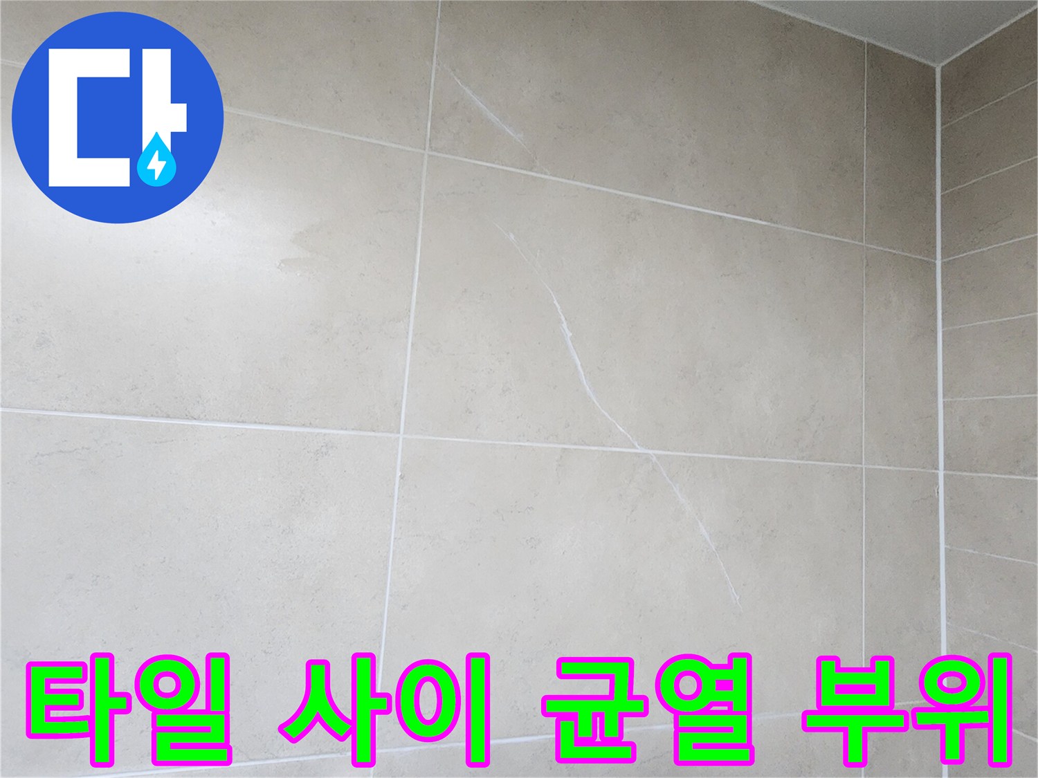 욕실 벽면 타일 접합부의 갈라진 틈새를 근접 촬영한 사진입니다.