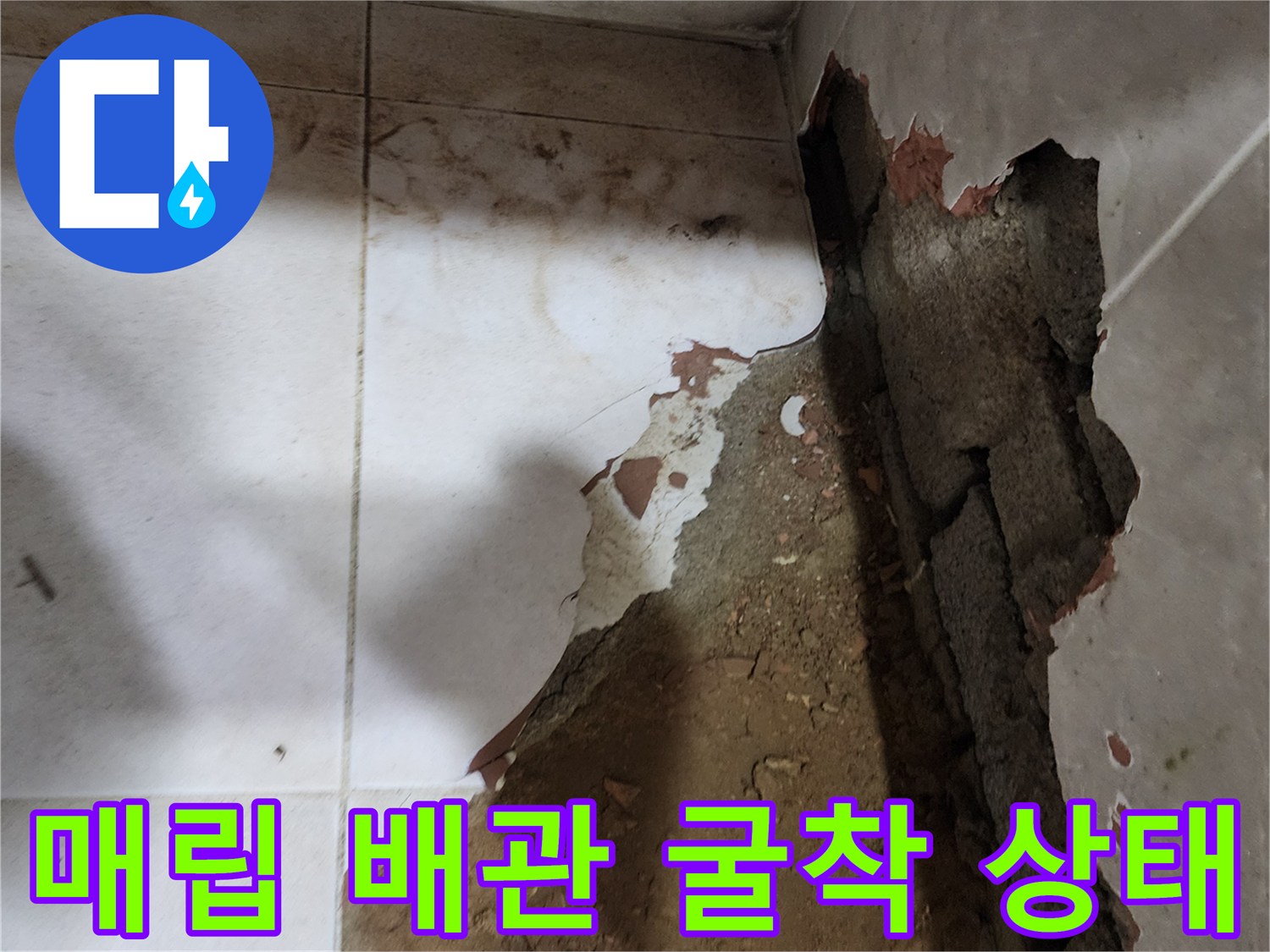 벽면 타일을 제거한 후 드러난 배관 주변의 흙과 구조물 모습입니다.