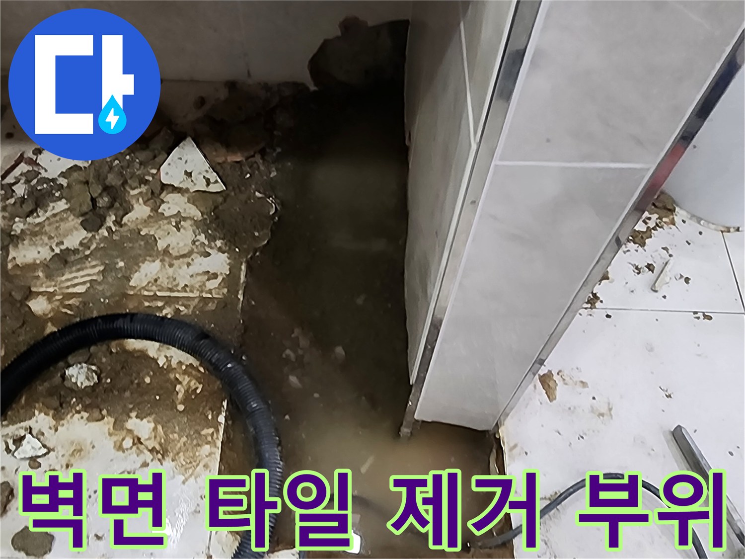 소변기 하단 벽면-배관 점검을 위해 파손된 타일 영역