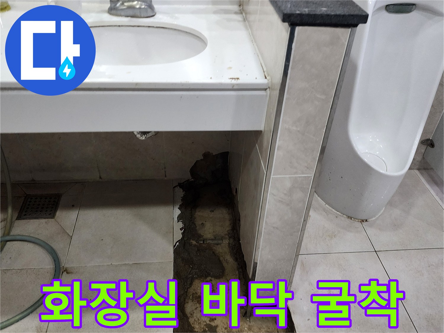 소변기 하부 배관 점검을 위해 타일을 제거한 화장실 내부 모습