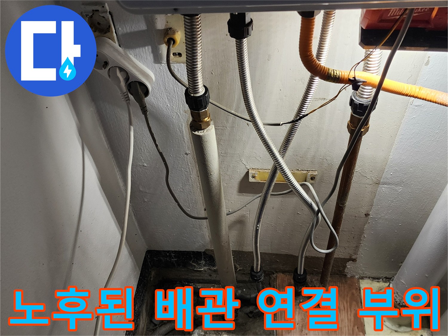 금속 주름관과 흰색 배관이 연결된 노후된 수도 설비 모습