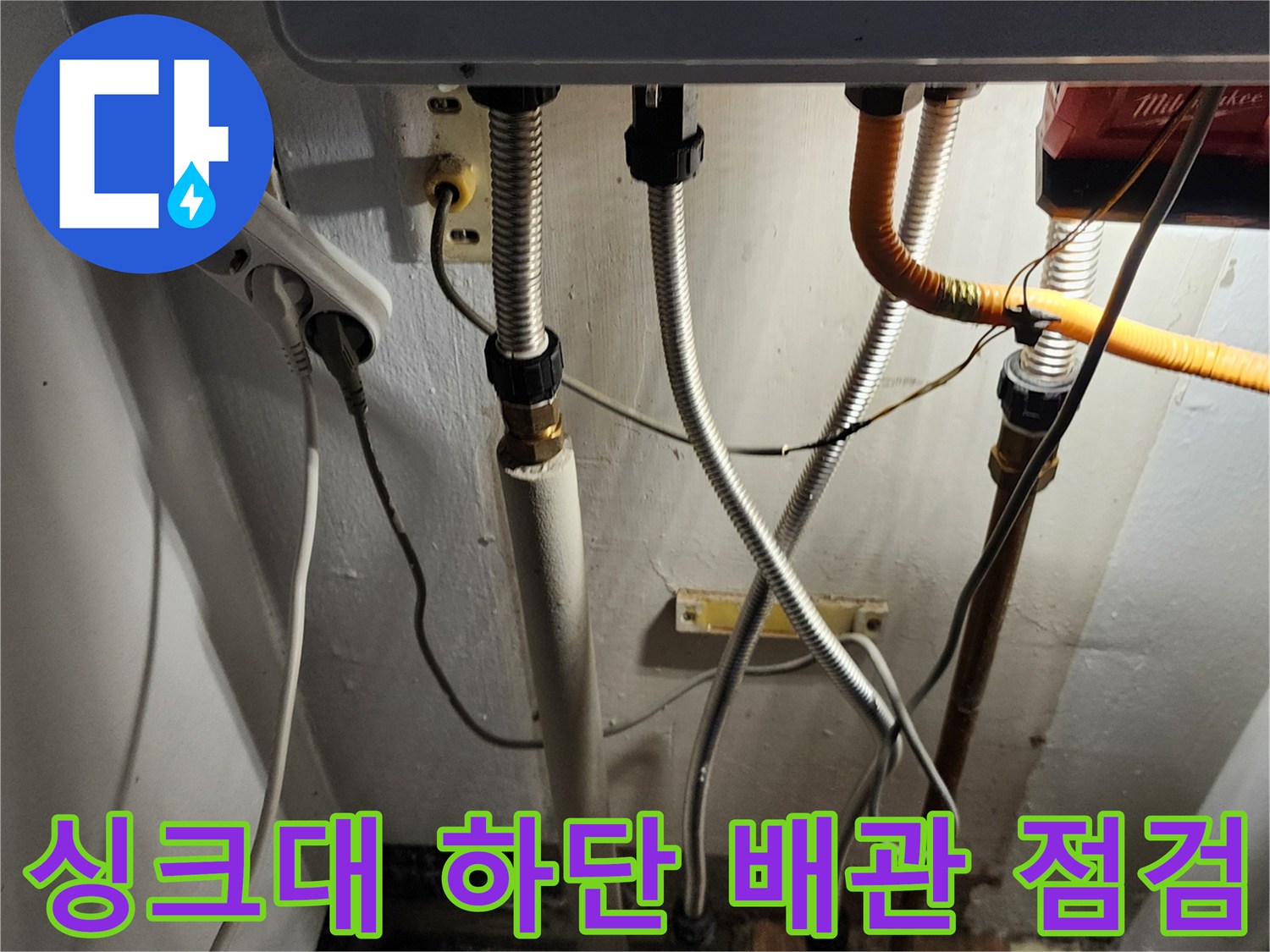 싱크대 아래쪽 은색 자바라 배관과 노란색 호스 배열