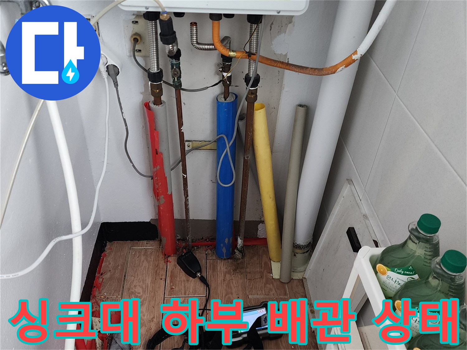 주방 싱크대 밑에 복잡하게 설치된 다양한 종류의 급수 및 배수 배관