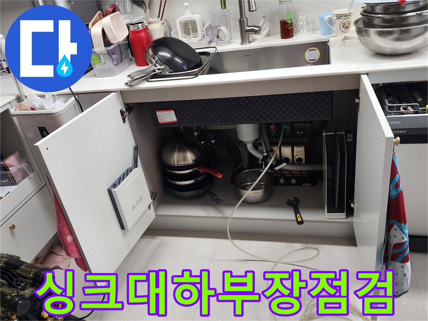 주방 하부장 내부의 배관 구조와 누수 확인용 공압 장비 배치