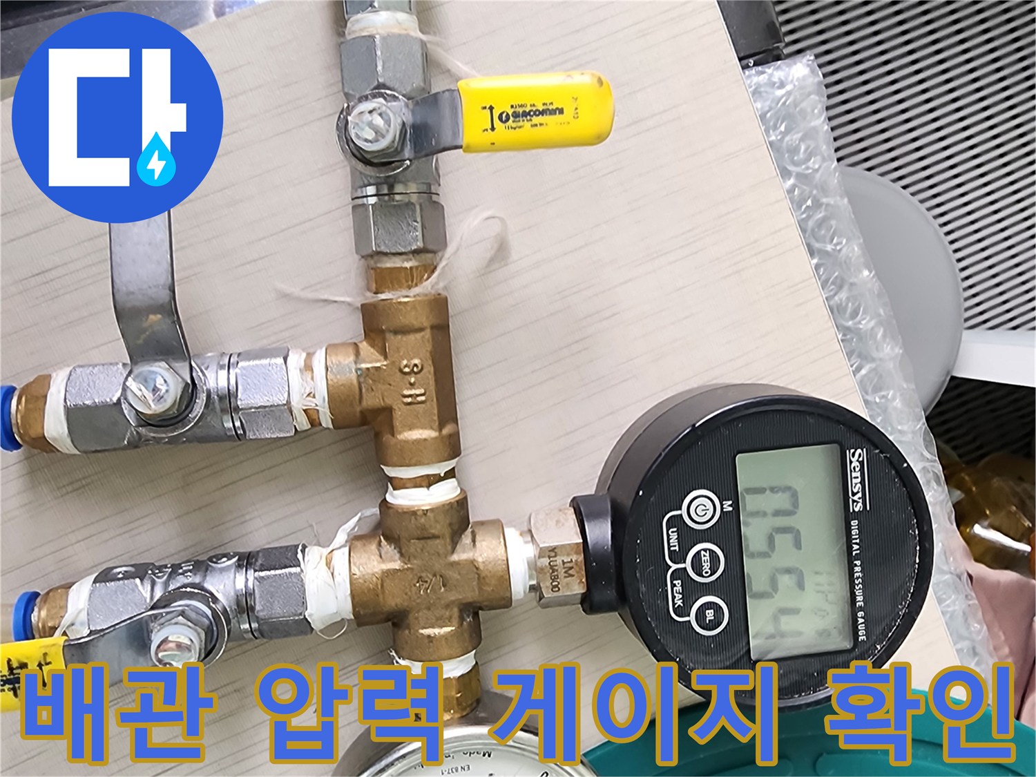 숫자가 표시된 디지털 장비와 금속제 분배기 밸브가 맞물려 있는 모습입니다.