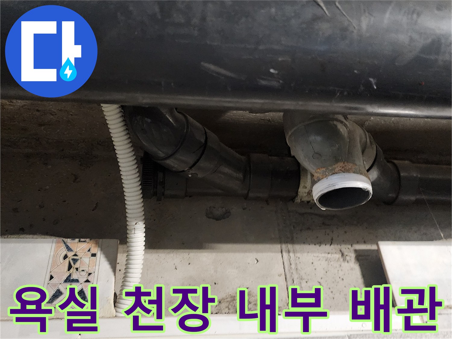 검은색 오수관과 흰색 주름관이 지나가는 천장 안쪽 모습