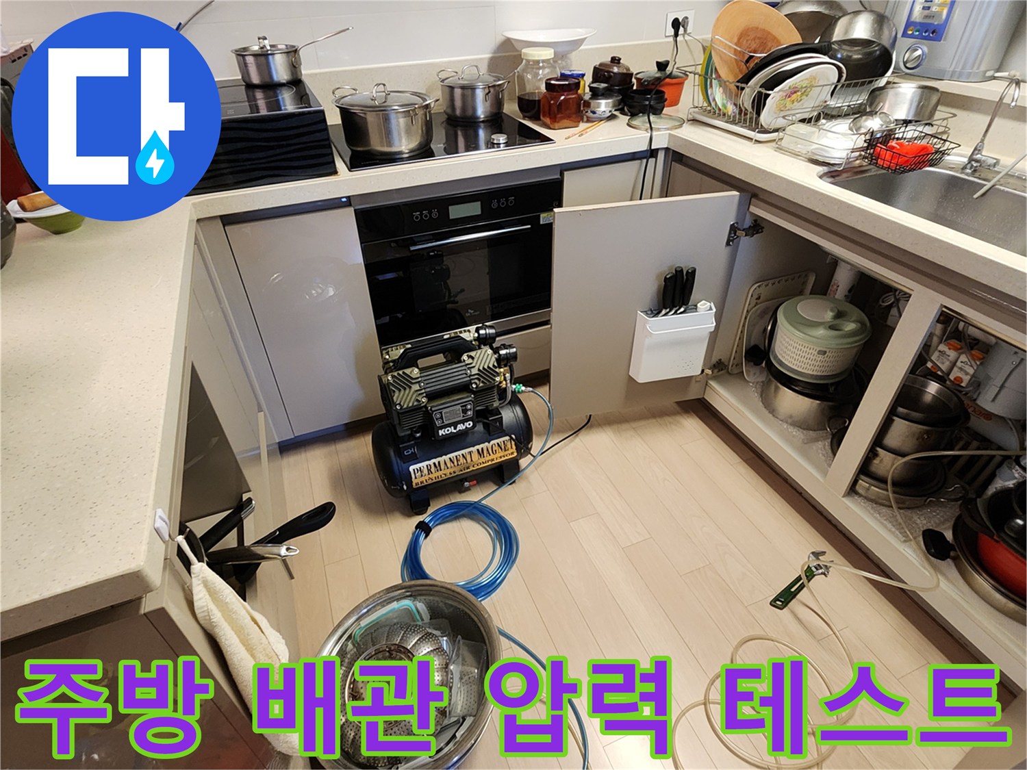 싱크대 밑 공간에 배치된 공압식 누수 점검 장비와 호스