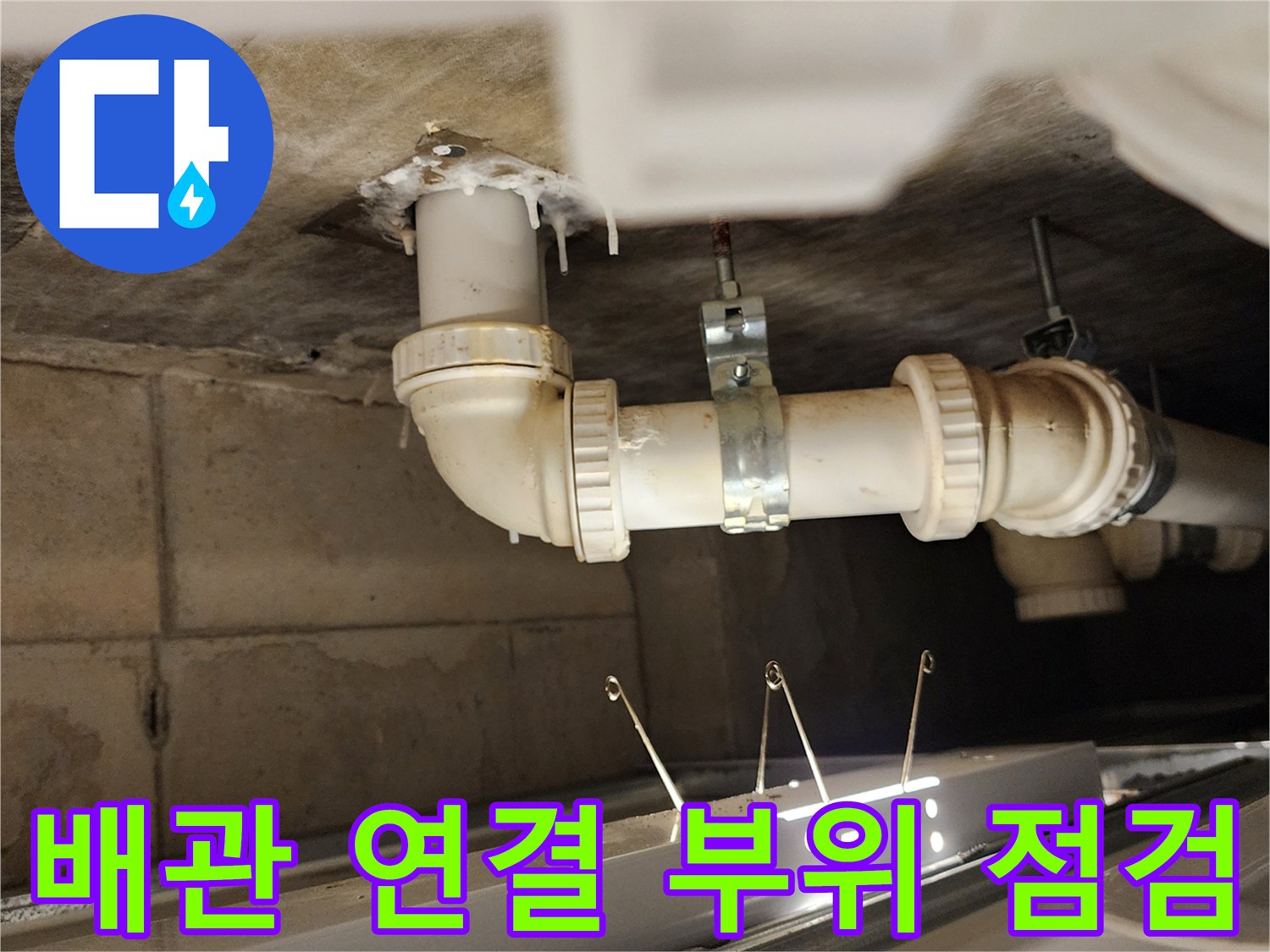 천장 배수 파이프의 연결 부위를 정밀하게 점검하는 모습입니다.