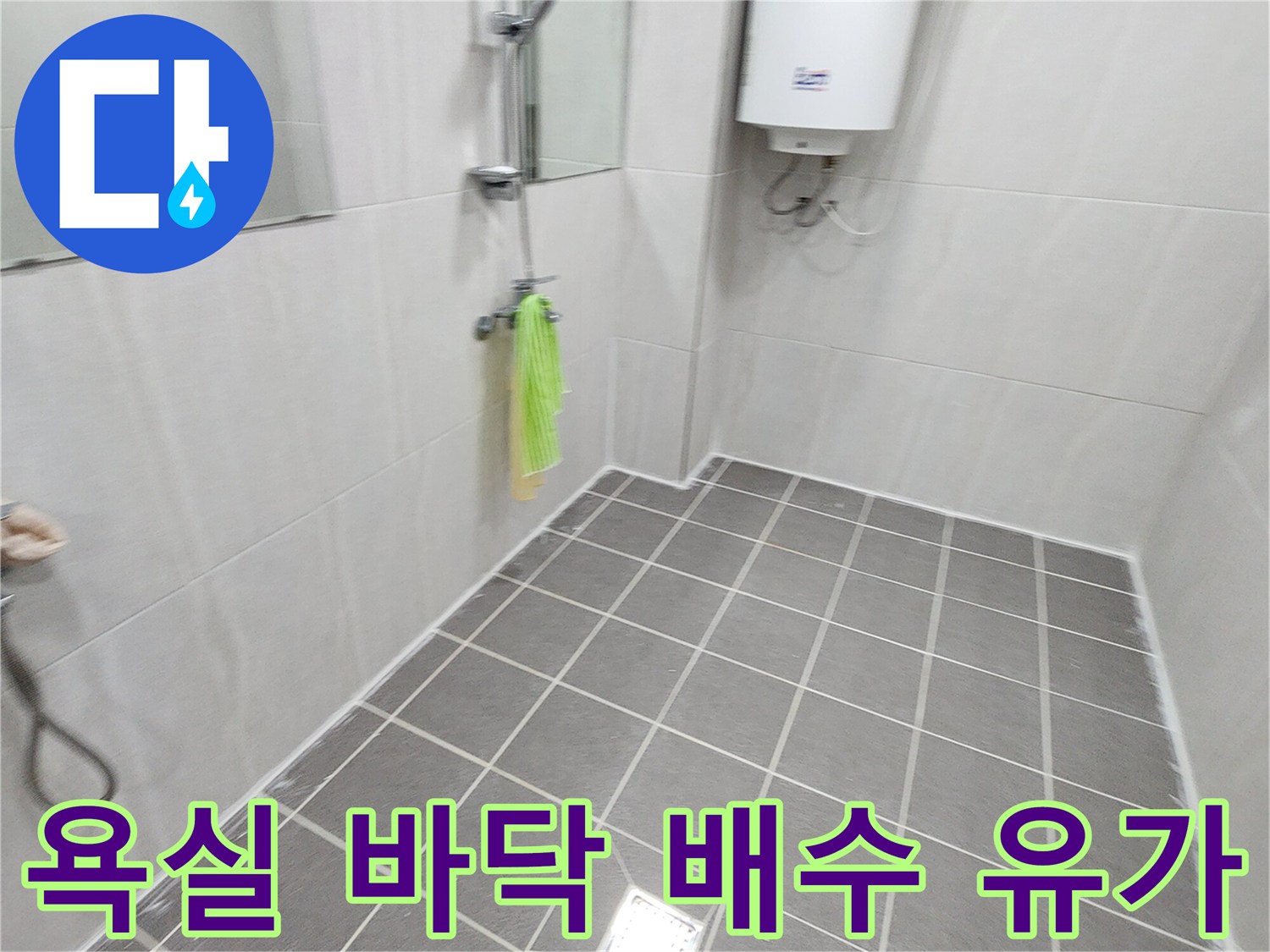 회색 사각형 타일과 중앙의 스테인리스 배수구 덮개 사진입니다.