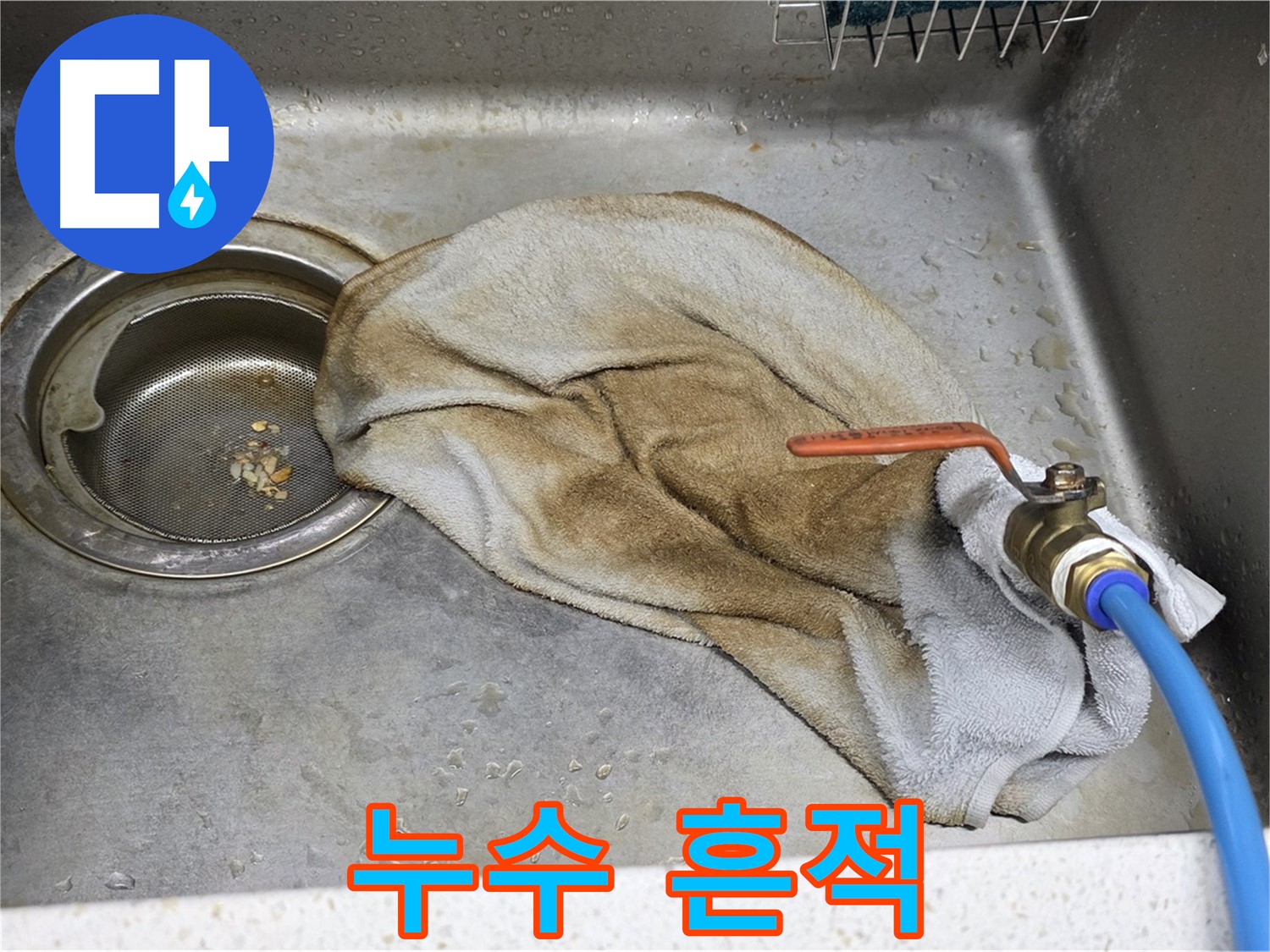 싱크대 주변 누수 - 젖은 수건이 누수 발생 위치를 암시합니다.