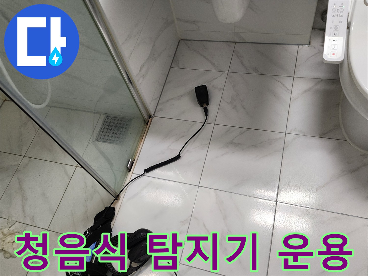화장실 바닥에 놓인 누수 탐지용 청음 장비와 연결선