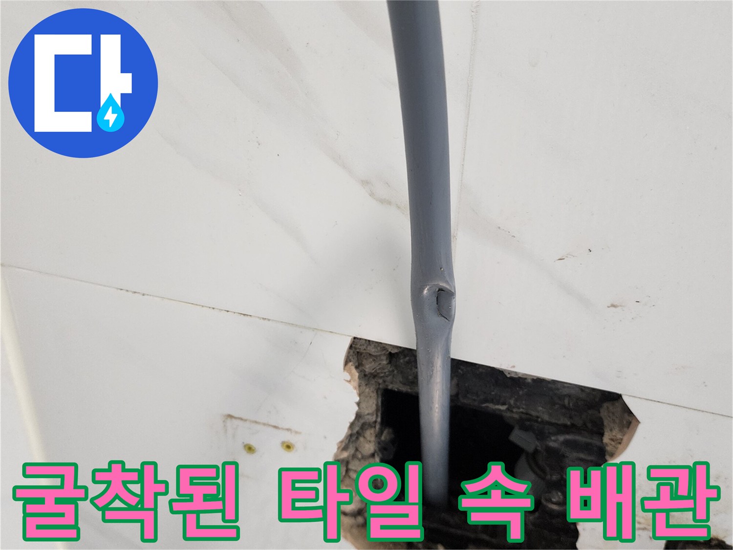 타일 틈새로 드러난 회색 배관의 상태 - 매립 배관 보수 작업