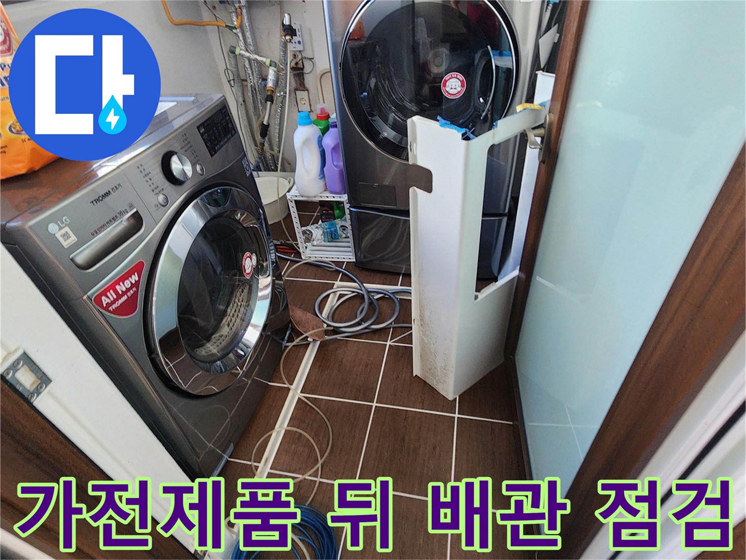 세탁실 가전제품 사이의 복잡한 호스 및 배관 연결 부위 사진입니다.