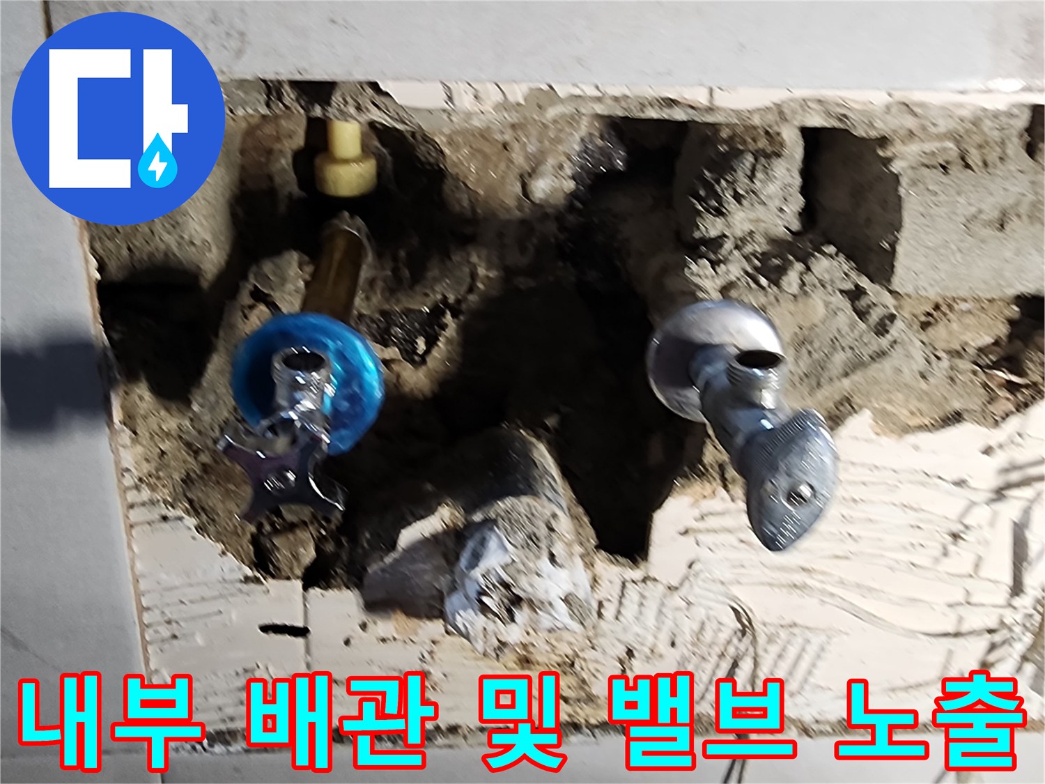 타일 제거 후 드러난 벽 내부의 수도 부품과 배관 상태를 보여줍니다.