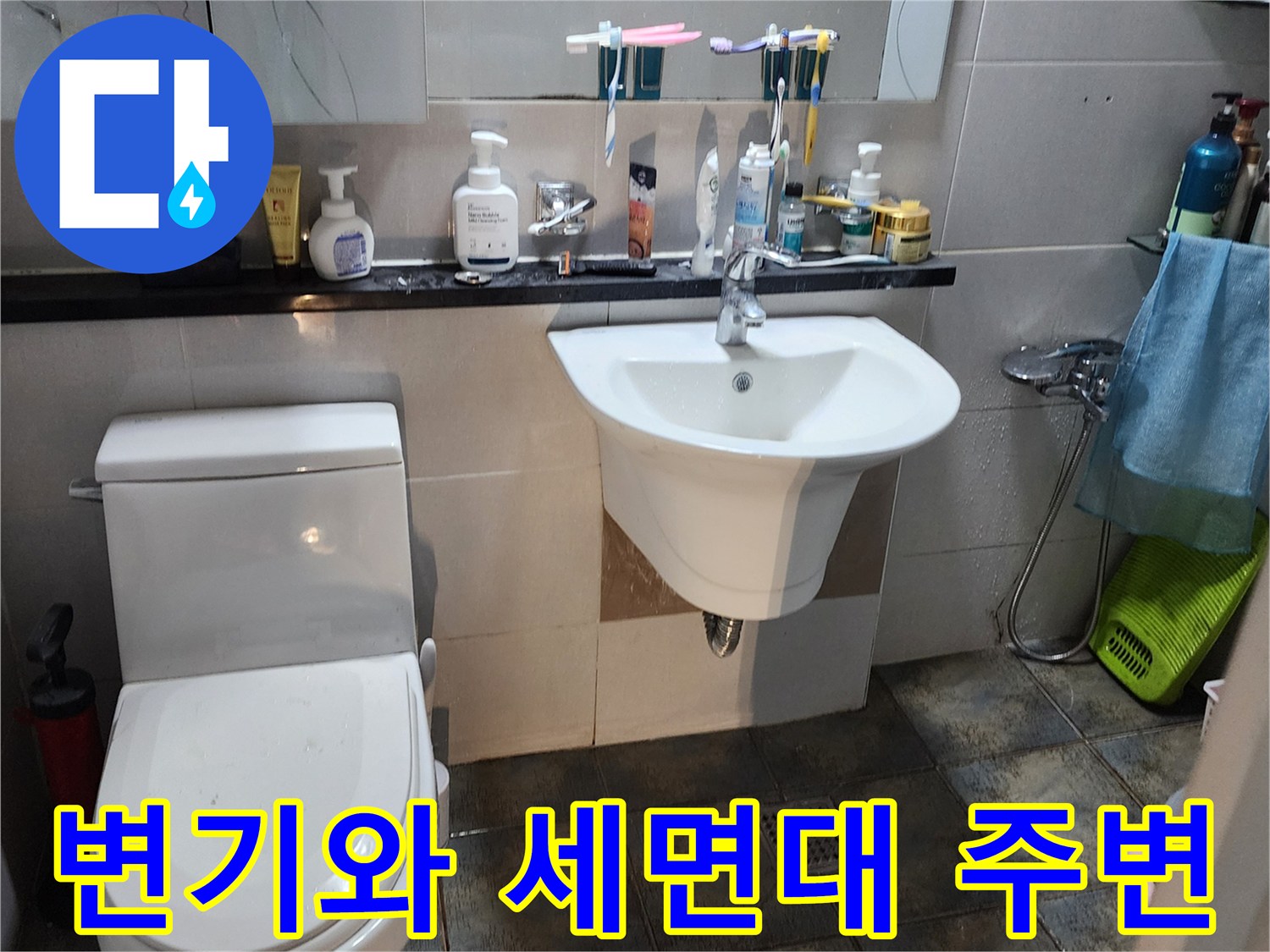 화장실 변기와 세면대가 설치된 벽면의 전체적인 모습입니다.