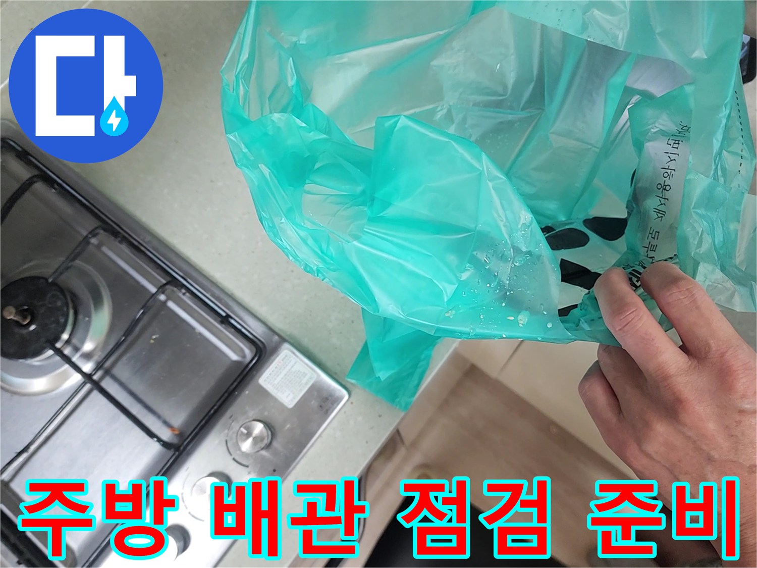 가스레인지 옆 비닐로 덮여 있는 싱크대 하단부