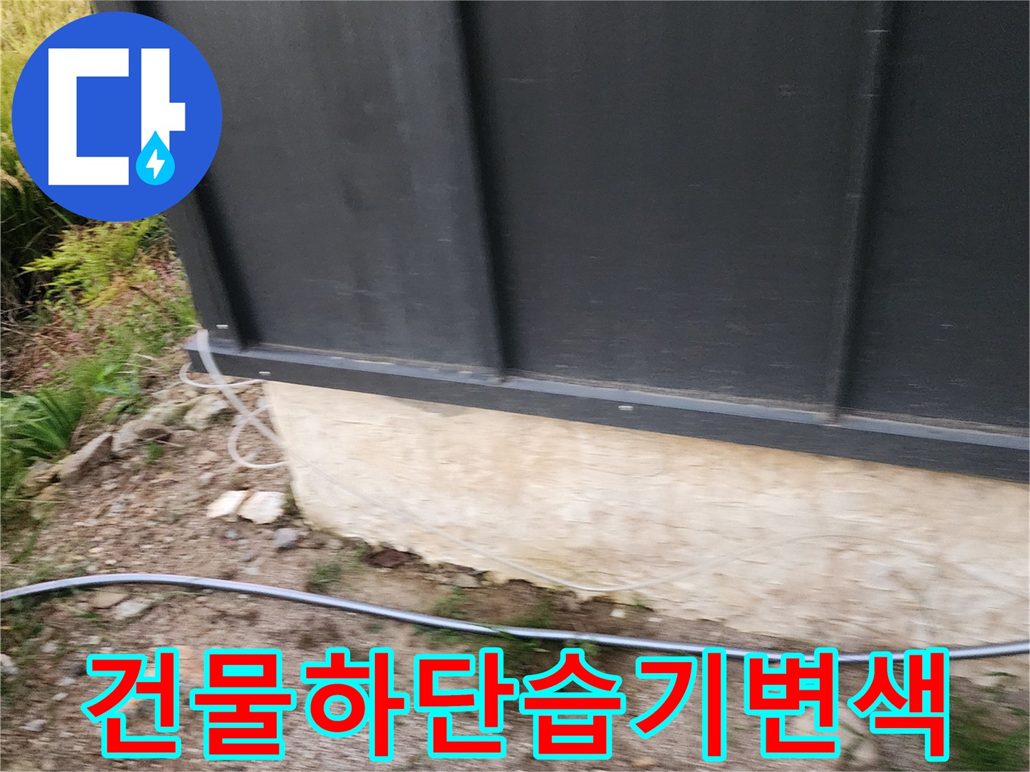검은 판넬 하부의 젖어 있는 콘크리트 표면