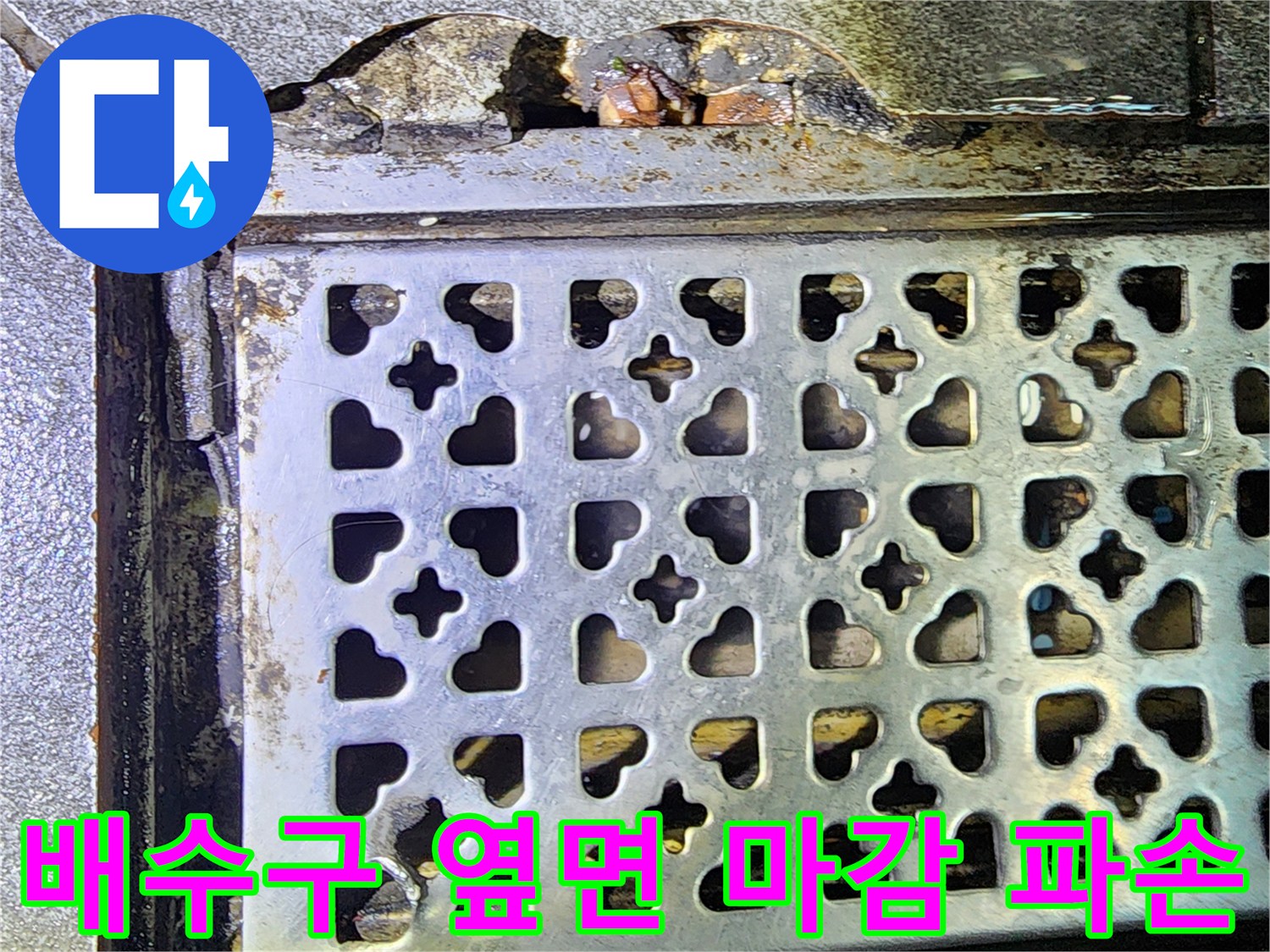 금속 트렌치 덮개와 깨져 있는 주변 바닥재의 근접샷